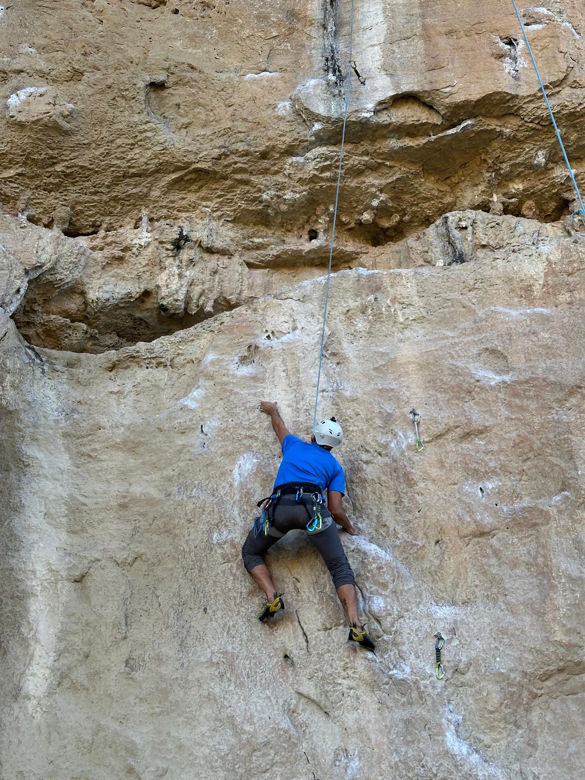 Escalador con casco en una pared de caliza de Chulilla
